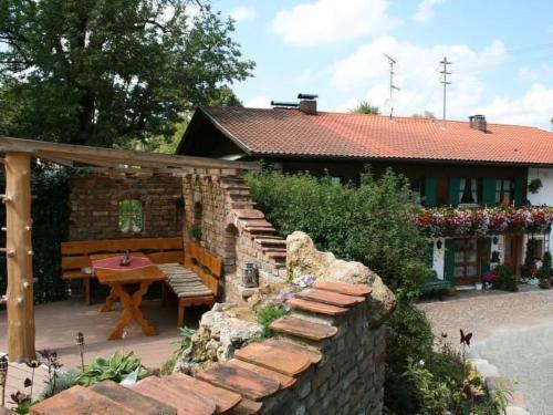 a house with a stone wall and a table and a bench at Apartment Bärli by Interhome in Bad Bayersoien