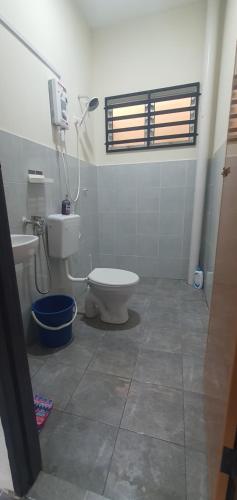 a bathroom with a toilet and a sink and a window at REZEKI MUEZZA 3BR2B Cozy Homestay in Teluk Intan