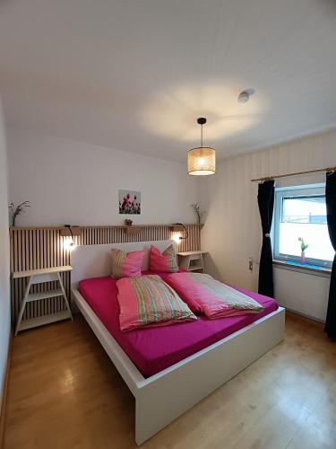 a bedroom with a large bed with pink sheets at Stylish & Spacious Apartment with Patio in Stams