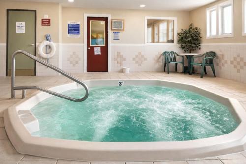 a hot tub in a room with a table and chairs at Fireside Inn and Suites in Devils Lake