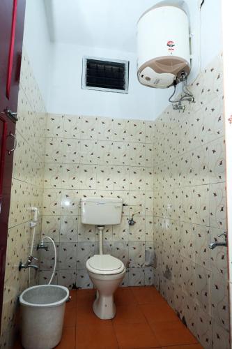 a bathroom with a toilet and a shower in it at Aroma Resort Hill Palace in Kolli Hills