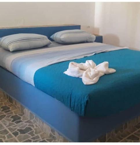 a blue bed with a white towel on it at Posada Doña Carmen in El Roque