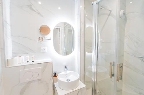 a white bathroom with a sink and a shower at Garbo hotel in Paris
