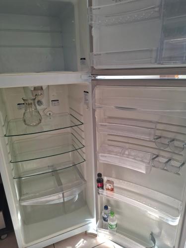 een witte koelkast met de deur open en de deur bij Apart próximo a Unimed, Catedral, HSA com 2 Ar e garagem in Santo Ângelo