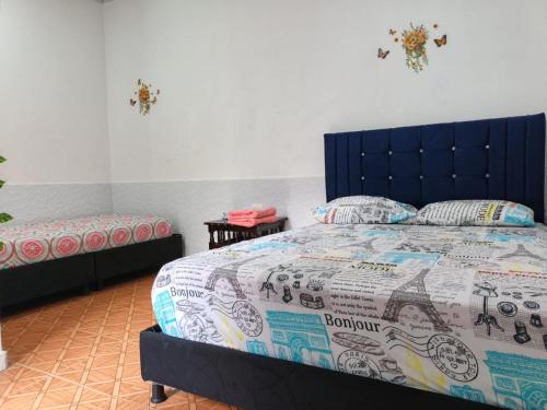 a bedroom with a bed with a blue headboard at VaRI in Tocaima