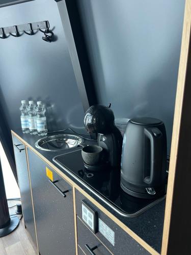 une cuisine équipée d'un micro-ondes et d'une cafetière sur une cuisinière dans l'établissement Aurorahut2 at Sauna Retreat, à Rovaniemi