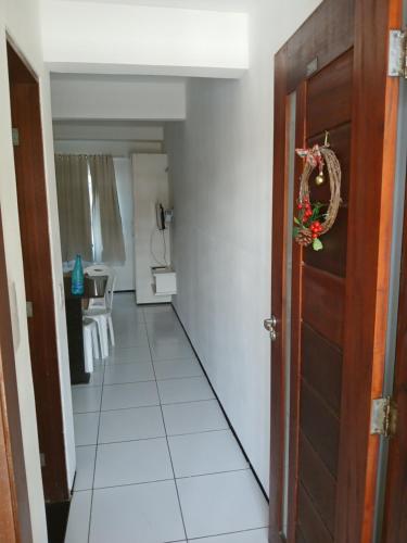 a hallway with a door and a white tile floor at Brisa Brasil Residence in Fortaleza
