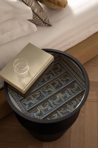 a plate with a candle and a book on a bed at Hotel Trame in Rome