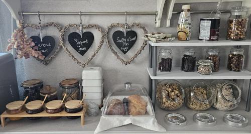 een voorraadkast met potten vol eten en hartjes aan de muur bij Lithos Luxury Rooms (Adults Only) in Adamas