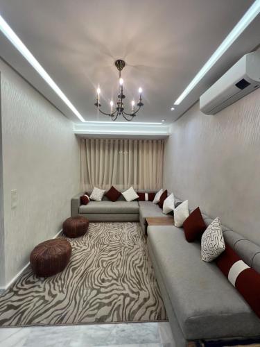 een woonkamer met een grote bank en een tapijt bij Luxury Appartement fes city fleur in Fès