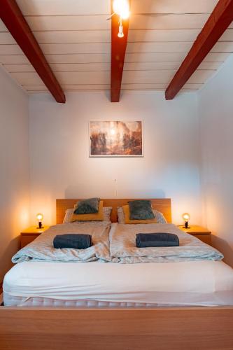 a bedroom with a large bed with two pillows at Abi-Lo Vendégház Nagypeterd in Nagypeterd