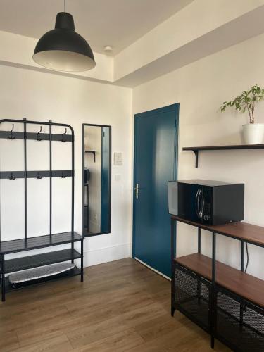 a living room with a blue door and a shelf at Au coeur de la Roche in La Roche-sur-Yon