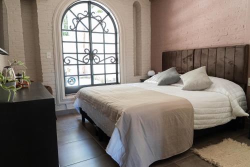 a bedroom with a large bed with a large window at Trento Hotel Boutique in San Salvador de Jujuy