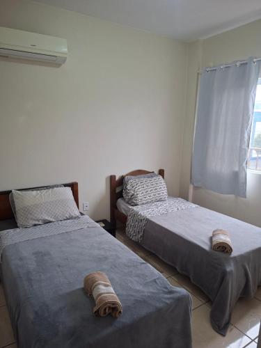 a bedroom with two beds and a window at Apart próximo a Unimed, Catedral e HSA com 2 quartos com 2 ARES e garagem in Santo Ângelo