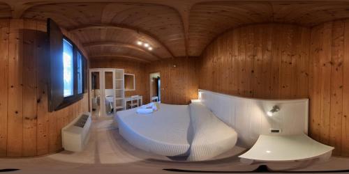 een kamer met een groot wit bed in een houten kamer bij La Carcara in Otranto
