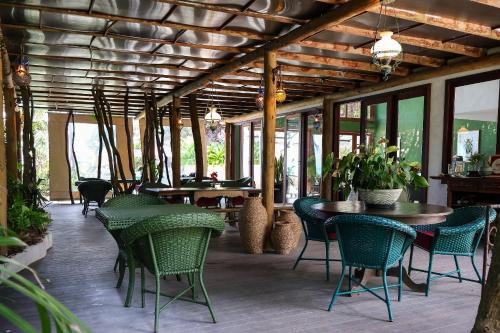 a patio with a table and chairs and tables and windows at Pousada Vila Corada in Pipa