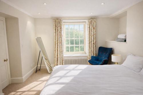 a bedroom with a bed and a window and a blue chair at Glandwr hall - 6 Bed - Magnificent Country House with Heated Swimming Pool & Jacuzzi in Barmouth