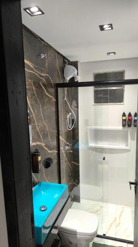 a bathroom with a blue sink and a toilet at Studio de Praia in Matinhos