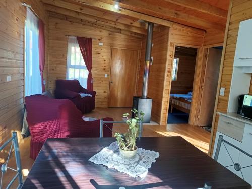 un soggiorno con tavolo in una casa di legno di Refugio Lemuy - Chiloé a Puqueldón