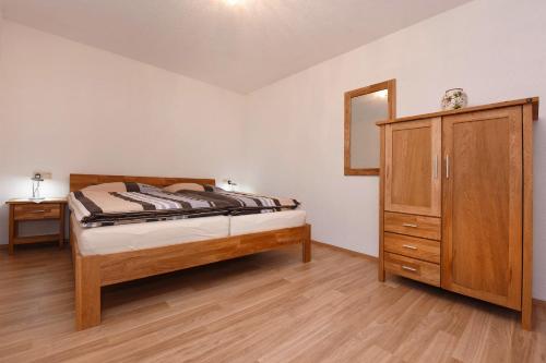 una camera da letto con un letto e una cassettiera in legno di Ferienwohnung Bitschnau Ulrike a Vandans