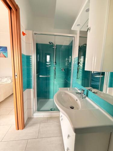 a bathroom with a sink and a glass shower at Supramonte Guesthouse in Agropoli