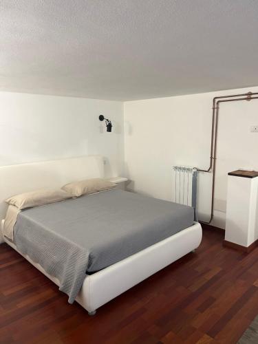 a white bed in a room with a wooden floor at Rent Room Sardegna in Porto Torres