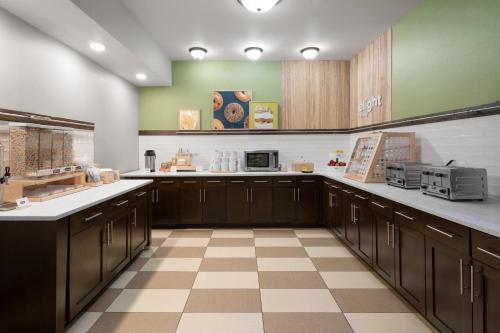 een grote keuken met bruine kasten en een geruite vloer bij Spark by Hilton Decatur in Decatur