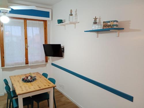 Zimmer mit einem Tisch mit Stühlen und einem TV in der Unterkunft EMAsolemare in Rosignano Solvay