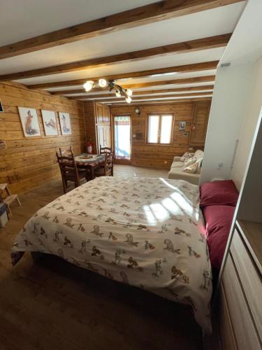 ein Schlafzimmer mit einem Bett in einem Zimmer mit Holzwänden in der Unterkunft La casa di Haka in Spogna