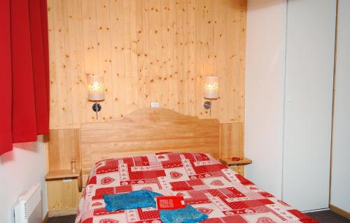 a bedroom with a bed with a quilt on it at Résidence Odalys Le Grand Panorama 1 in Valmeinier