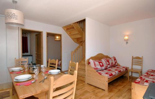 a kitchen and dining room with a table and a couch at Résidence Odalys Le Grand Panorama 1 in Valmeinier