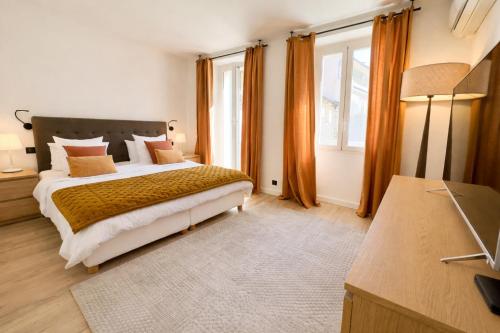 een slaapkamer met een groot bed en oranje gordijnen bij Luxueux 3 pièces -80m2 -2CH - 2 SDB -1mn de la Croisette et des plages in Cannes
