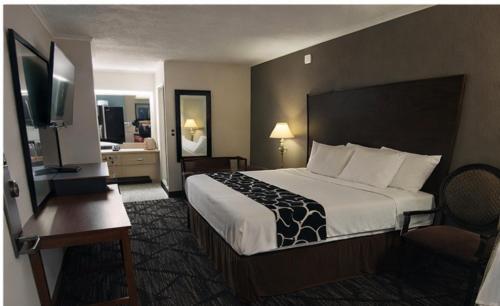 a hotel room with a bed and a flat screen tv at New Travel Inn in Kingsport