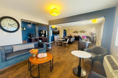 a living room with a couch and a clock on the wall at Red Lion Inn & Suites Junction City in Junction City