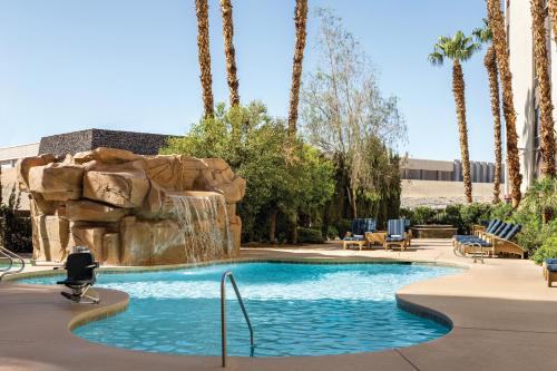 a swimming pool with a waterfall in a resort at Hampton Inn Tropicana in Las Vegas