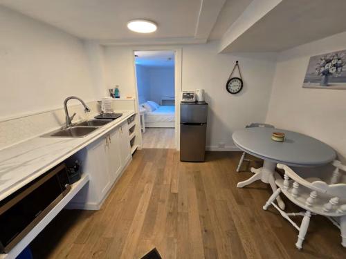 a kitchen with a sink and a table at Private 2-Bedroom Minutes From Trent University in Peterborough