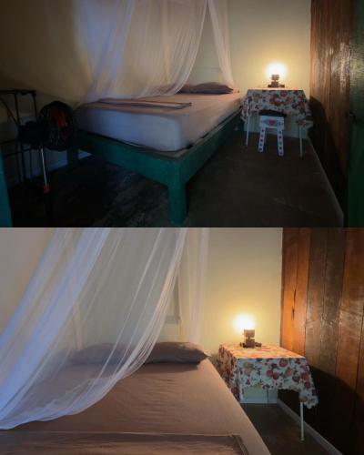 a bedroom with a bed and a table with a curtain at Casa Mamré in Cahuita