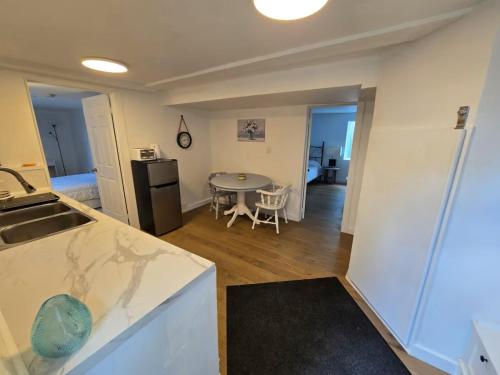 a kitchen and living room with a sink and a table at Private 2-Bedroom Minutes From Trent University in Peterborough