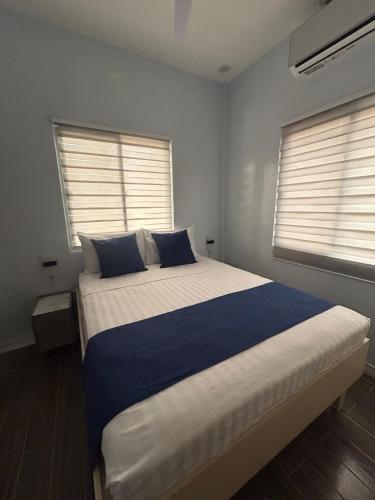 a bedroom with a large bed with two windows at Casa B Pasco in Dauin