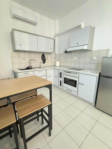 eine Küche mit weißen Geräten und einem Holztisch in der Unterkunft Olympus Embrace in Leptokaryá