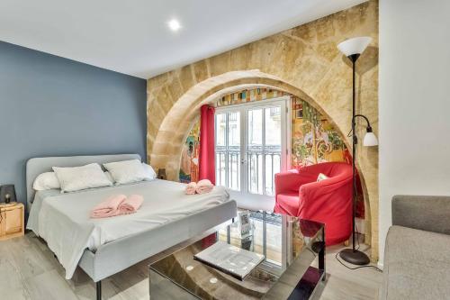 a bedroom with a bed and a chair and a window at Studio Alienor Place la Bourse Bordeaux in Bordeaux