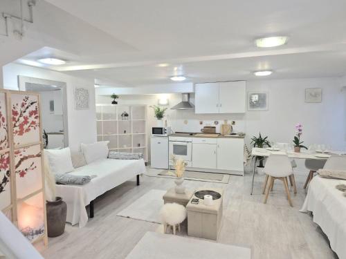 een woonkamer met witte meubels en een keuken bij Basement studio in hosts house with private terrace and BBQ Ideal for The camino in Zizur Mayor