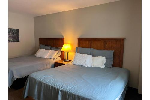 een hotelkamer met twee bedden en een lamp bij Pleasant Night Inn Watertown by Hotel O in West Carthage