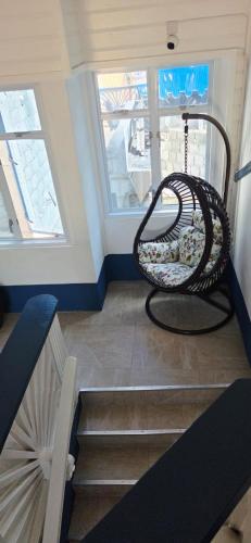 een trap met een schommel in een kamer met twee ramen bij Martha's House Tesla in Soufrière