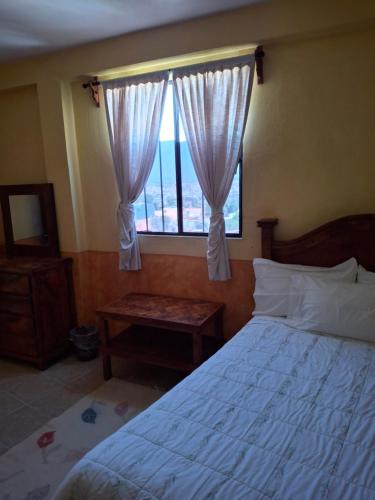 een slaapkamer met een groot bed en een raam bij Hotel planetario in San Miguel de Allende