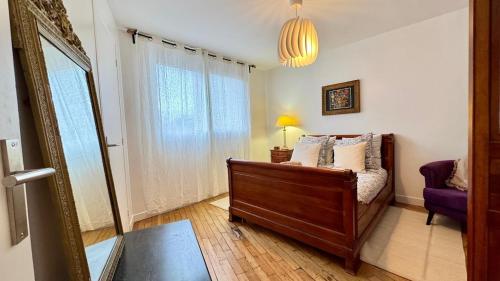 een slaapkamer met een bed en een spiegel bij Vue Paris 1 min de la gare in Saint-Cloud