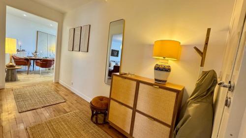 een woonkamer met een lamp op een dressoir bij Vue Paris 1 min de la gare in Saint-Cloud