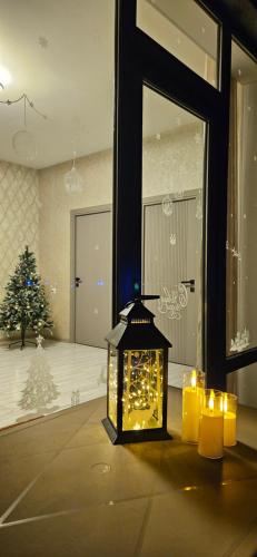 a lantern with candles in a room with a christmas tree at Arevot Ojakh in Areni