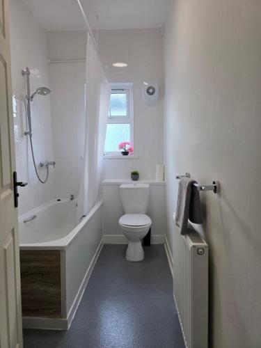 a bathroom with a tub and a toilet and a window at Magic Stays! in Halton