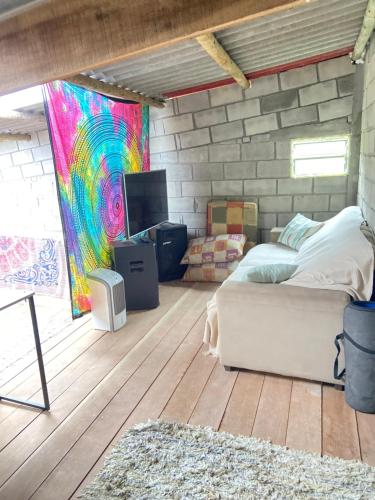 una camera da letto con un letto e una TV in una stanza di Sítio Buscafé a Ibicoara